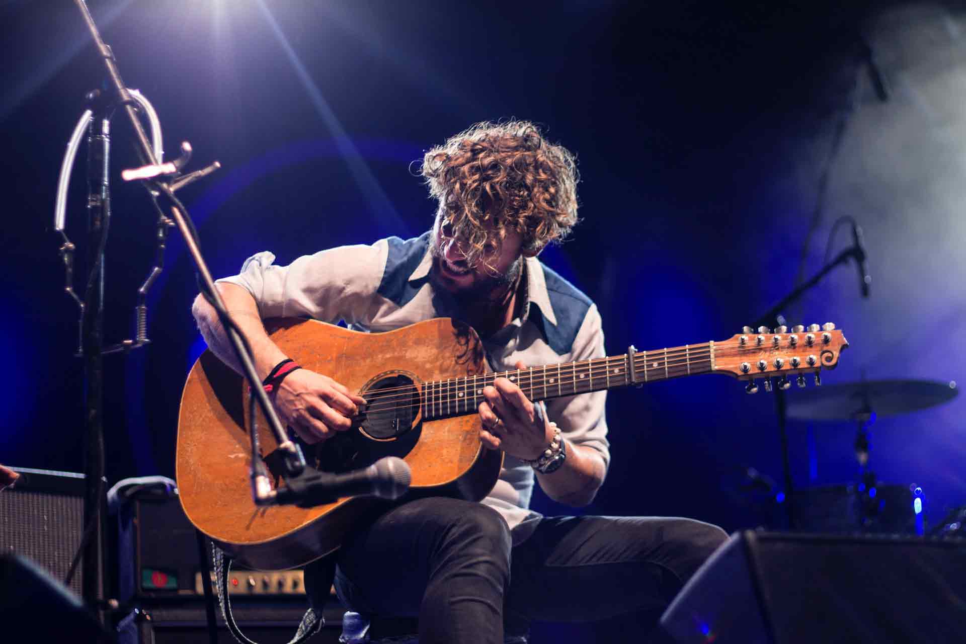 man-playing-guitar-sitting-on-chair-1425297